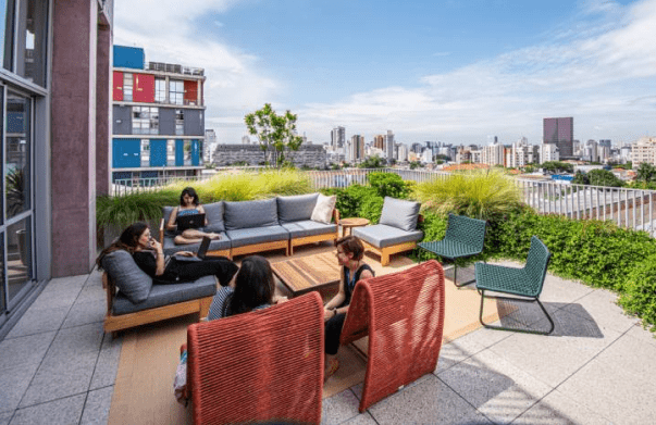 Área comum externa do Edifício 555 com pessoas sentadas em sofás