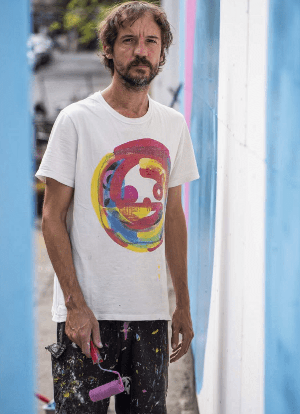 Celso Mazu, conhecido como Prozak, próximo ao painel pintado