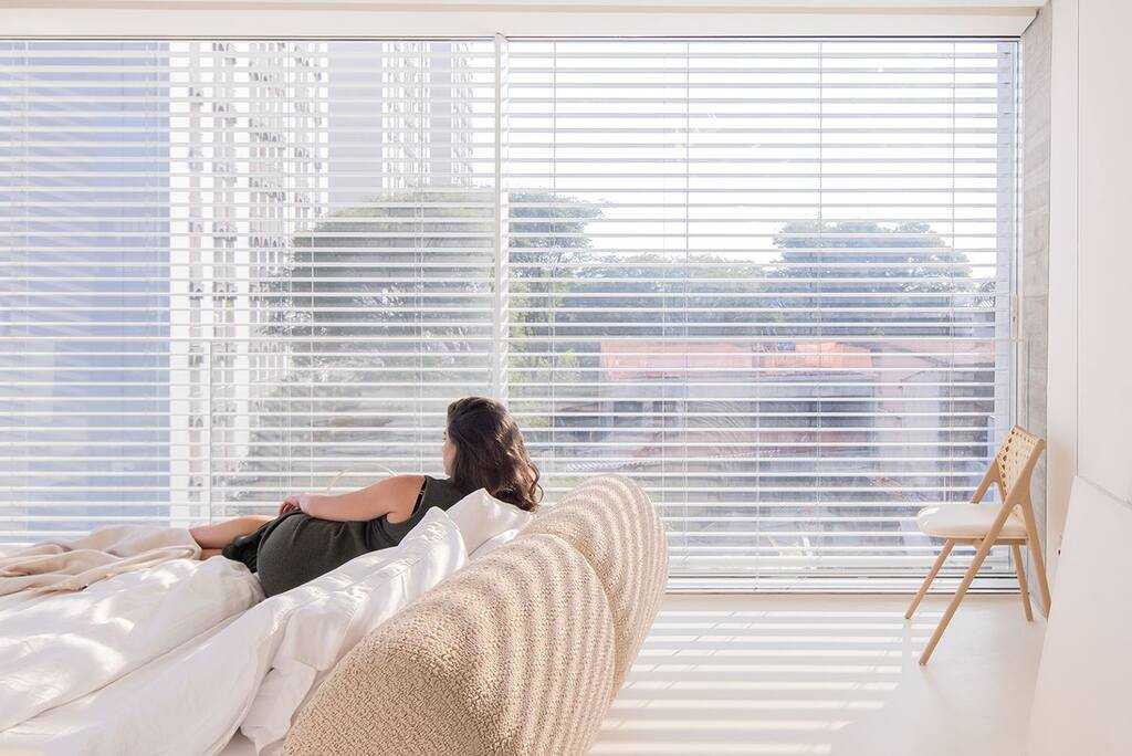 mulher em sofá de imóvel, representando a iluminação em apartamentos