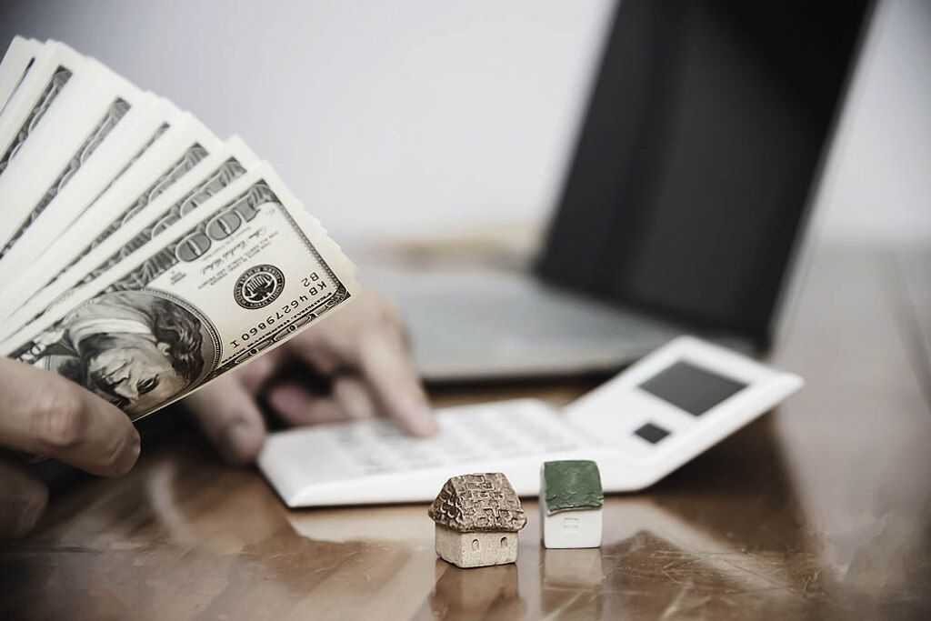 pessoa com notas de dinheiro calculando o valor para investir em imóveis
